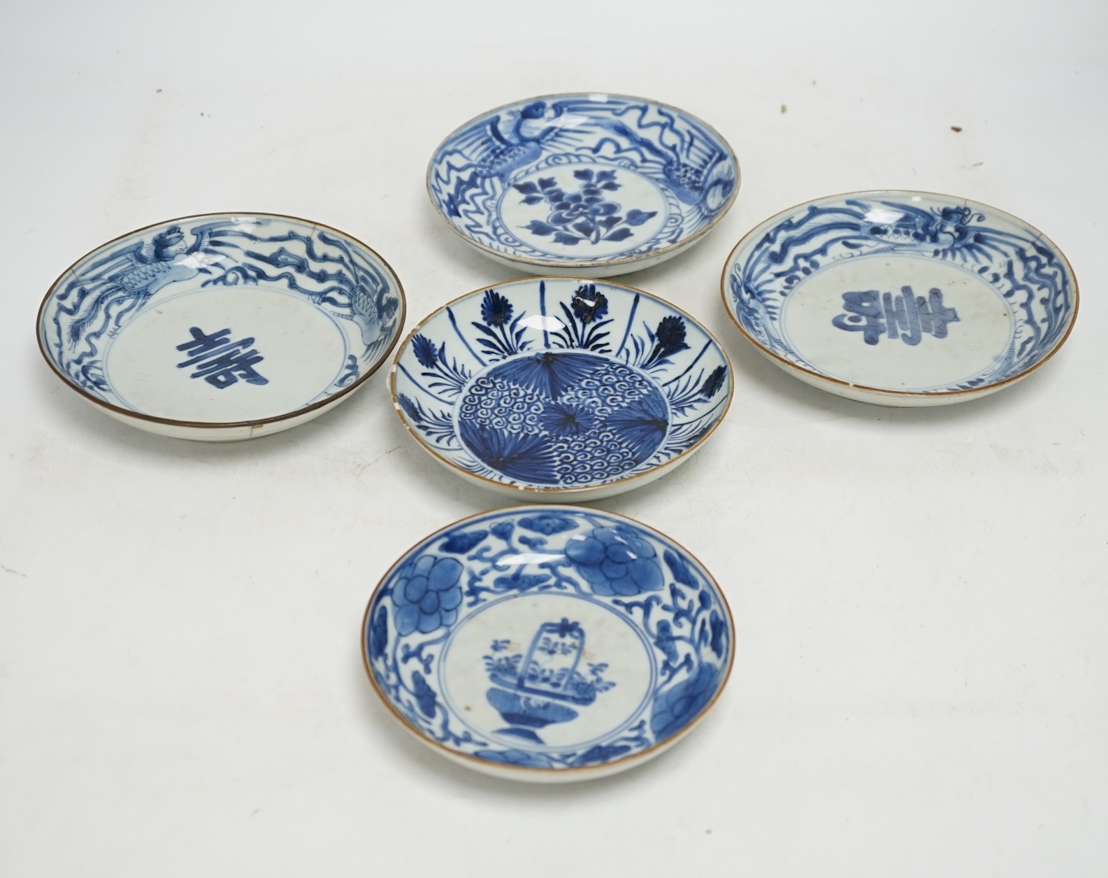 Five variously patterned Chinese blue and white saucer dishes, Kangxi period, largest 16cm diameter. Condition - chips and cracks to three items
